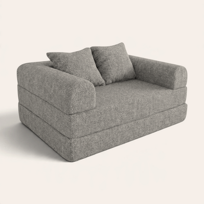 Sofá cama modular Naap Concept Teddy en color gris con textura suave y dos cojines decorativos